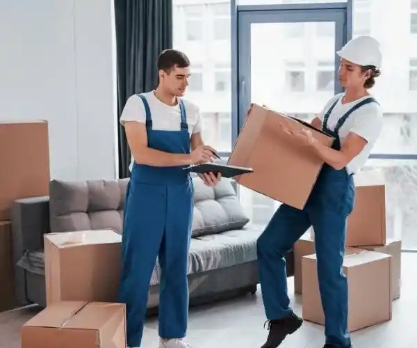 Friendly movers from Expert Movers handling household boxes with checklist